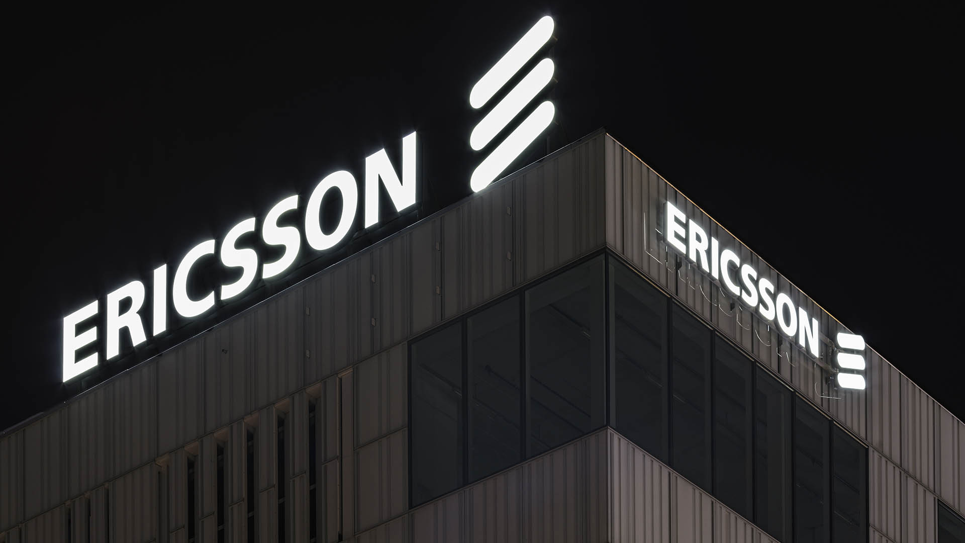 Ericsson sign atop the company's headquarters at night.